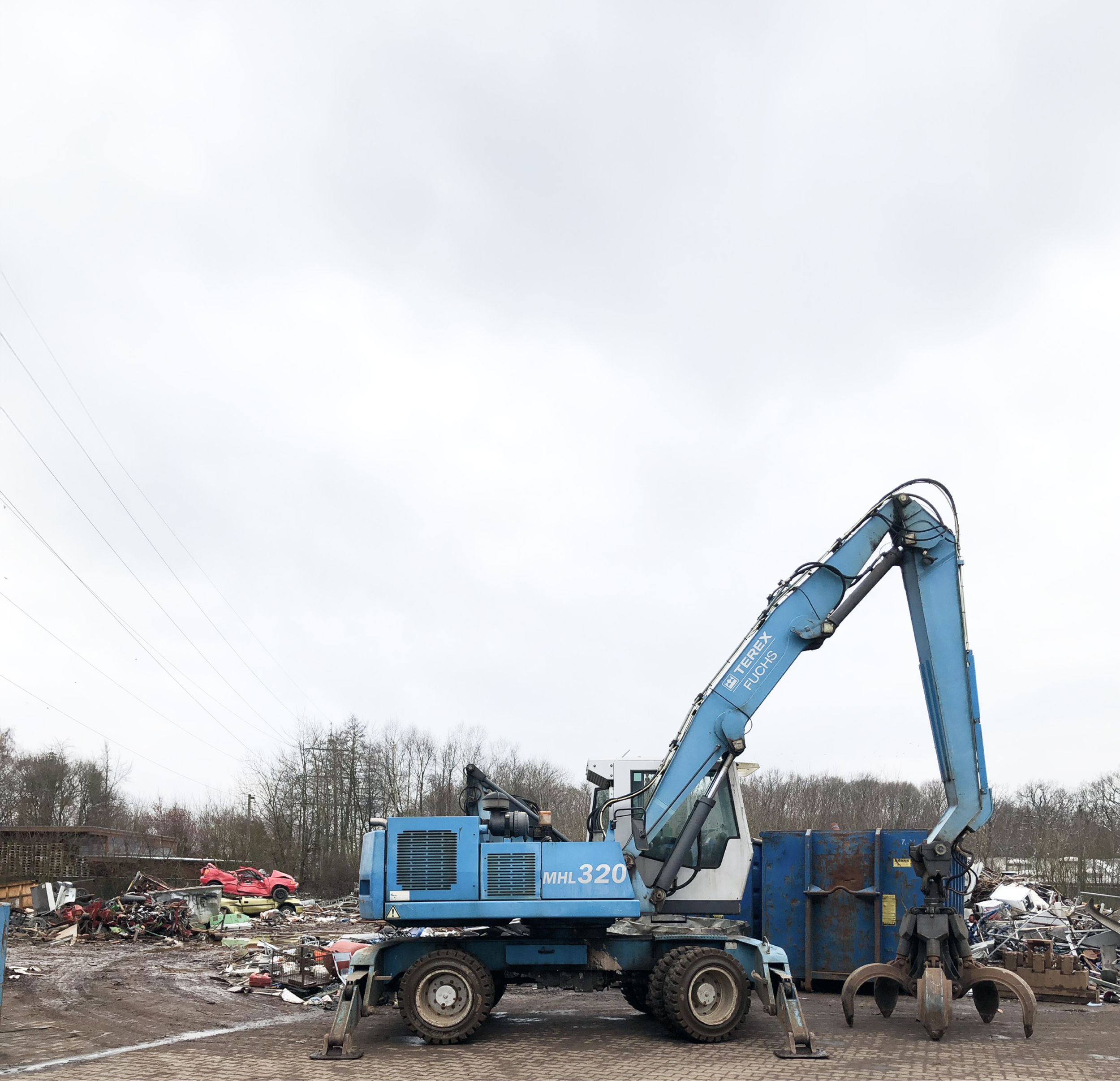 Blauer Schrottmetallgreifer auf einem Schrottplatz